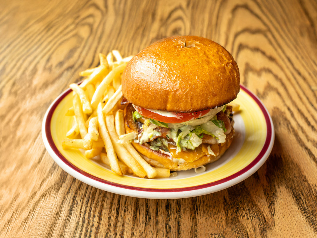 Bacon cheeseburger on brioche with fries at La Ñapa